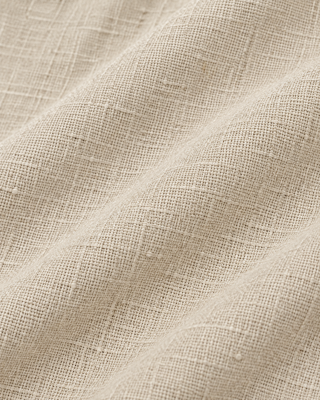 Macro view of the textured beige linen cotton fabric used in the pajama pants