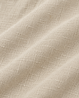 Macro view of the textured beige linen cotton fabric used in the pajama pants