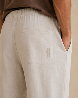 Close-up of cream pants back patch pocket with tonal Nostalgic Since Forever embroidery