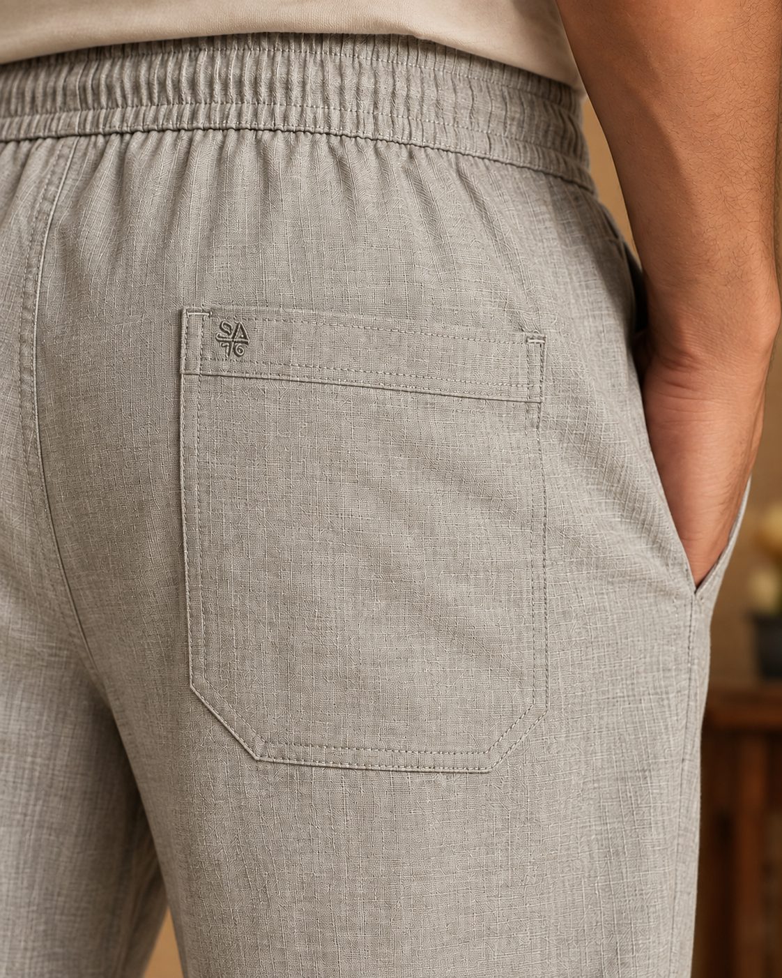 Close-up of grey linen cotton pajama pants back patch pocket with tonal SA embroidery