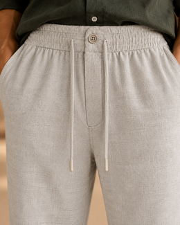 Close-up of grey linen cotton pajama pants elastic waistband, front button and drawcord