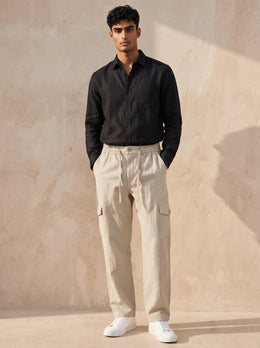 Man wearing Solah Anna cream cotton cargo pants in a full front view